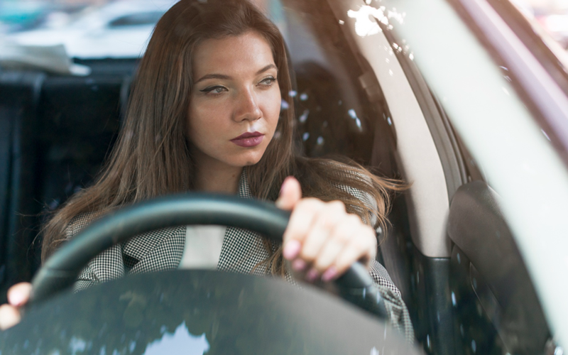 Fotografia ilustrativa de uma mulher no volante de um carro