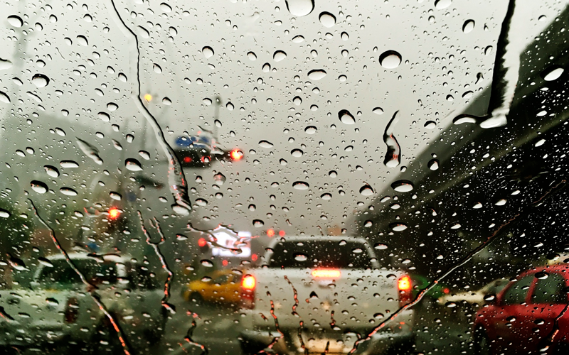 Fotografia ilustrativa de um parabrisas com gotas de chuva